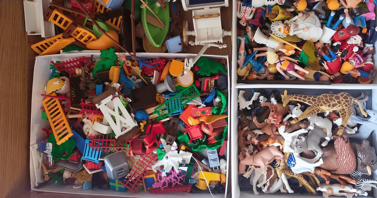 Des jouets d’enfants éparpillés dans des bacs, illustration du rangement des jouets, bannière de l’article Aider les enfants à ranger sans difficulté : 3 méthodes selon les moments de la journée sur le blog d’une ex-bordélique.