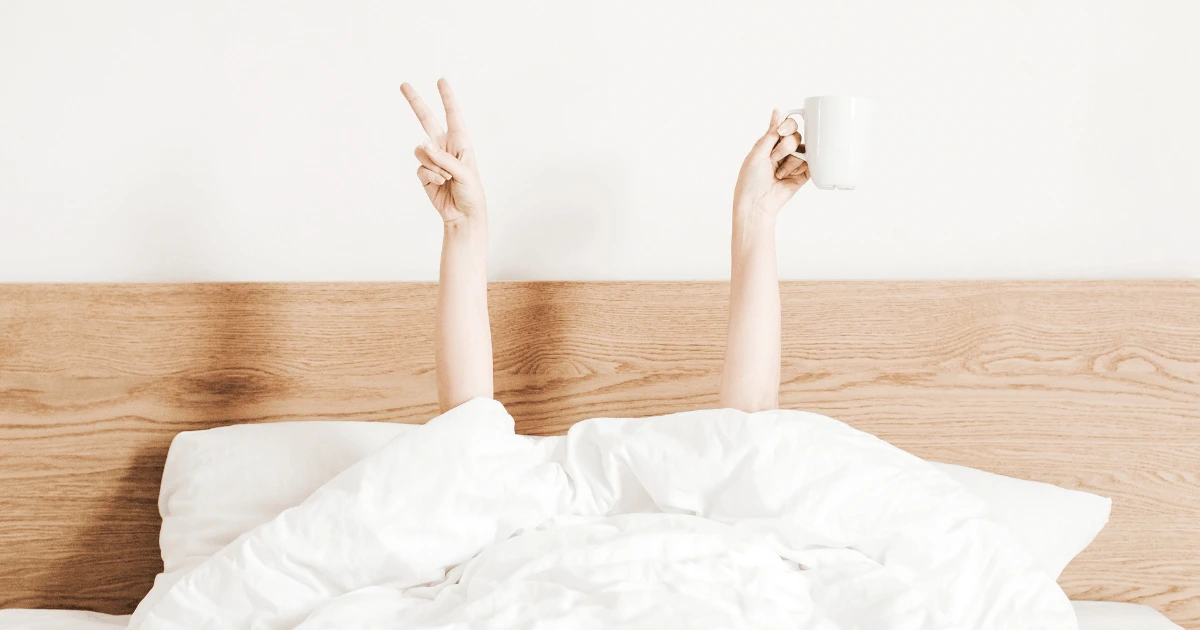 Personne dans son lit qui semble joyeuse