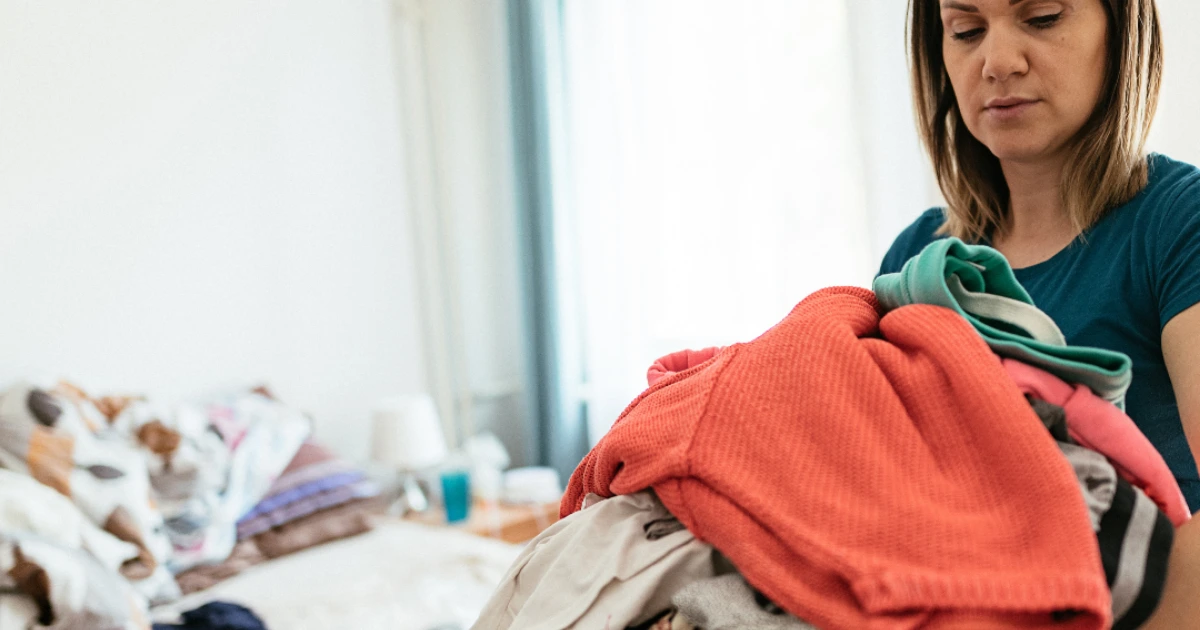 Femme qui porte du linge et semble stressée